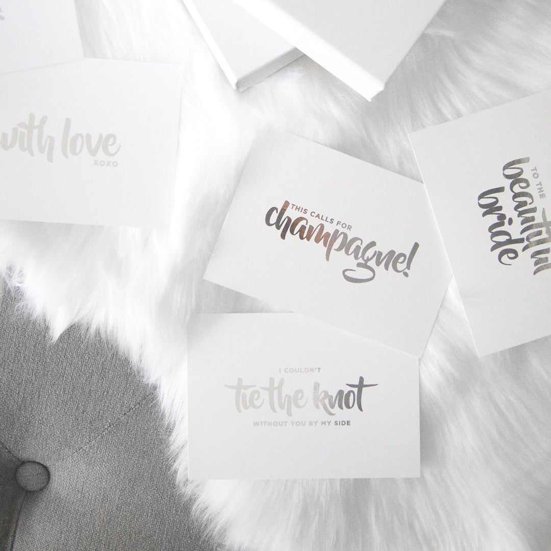 Midnight Mischief silver foiling gift cards positioned on a fluffy white mat. They contain some phrases such as "I could not tie the not without you by my side".