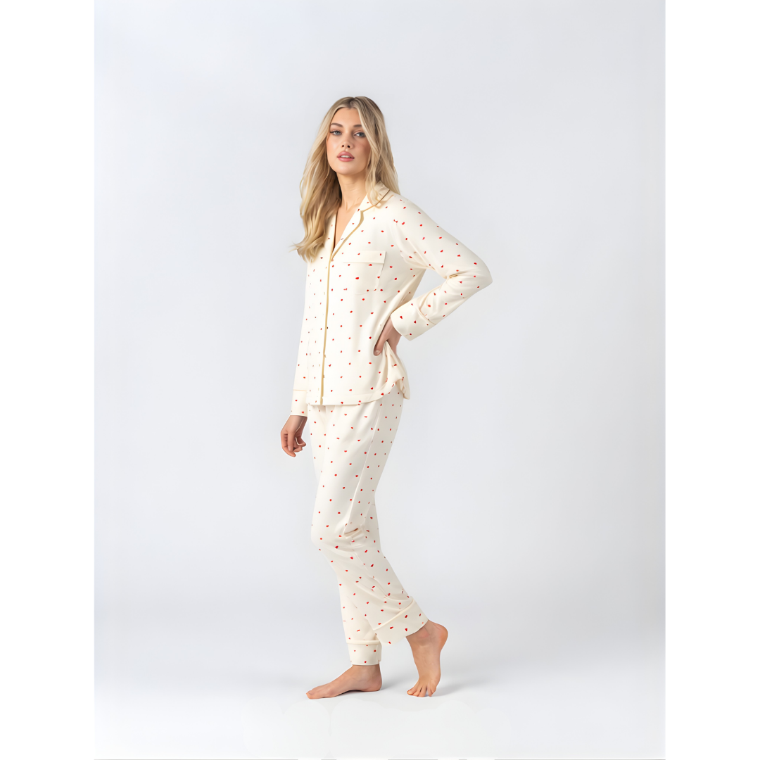 Side view of model wearing Midnight Mischief cream soft modal pyjamas with red heart pattern and long pants.